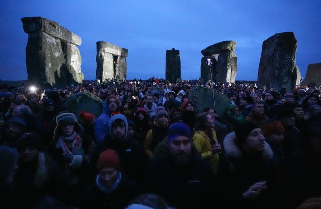 People take part in the winter solstice celebrations during sunrise at the Stonehenge prehistoric monument on Salisbury Plain in Wiltshire