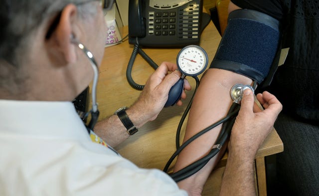 GP taking a patient's blood pressure