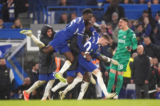 Chelsea's Cole Palmer, right, celebrates his winner against Manchester United as team-mates jump on his back