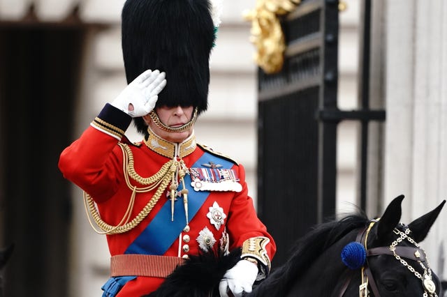 The King salutes as he departs Buckingham Palace for the Trooping the Colour ceremony at Horse Guards Parade