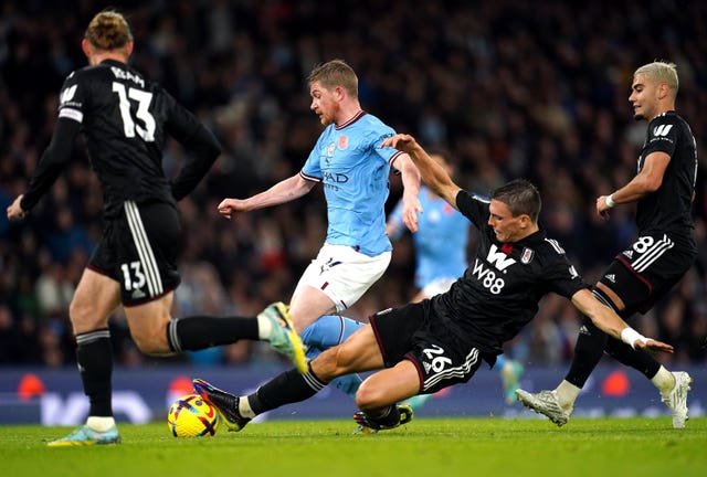 Fulham's Joao Palhinha, centre right, tackles Manchester City's Kevin De Bruyne