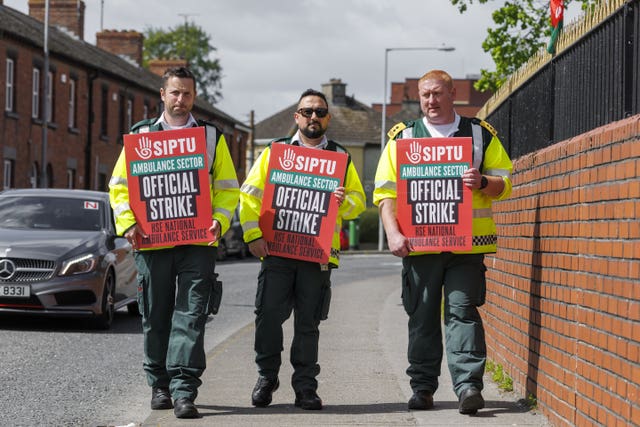 National Ambulance Service workers holing strike placards