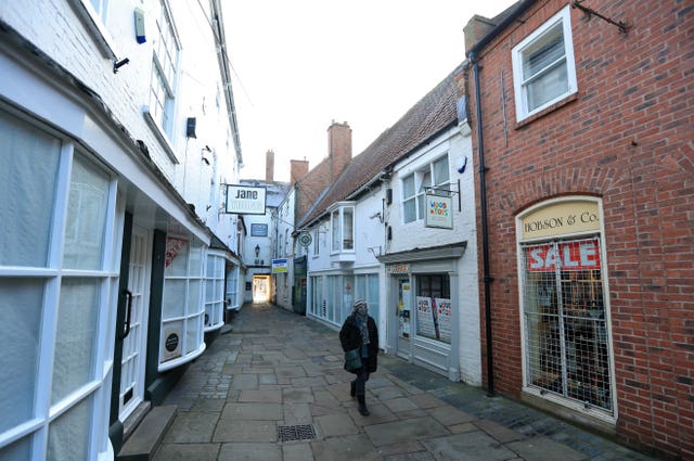 A person walks down a quiet street with closed shops in Newark-on-Trent