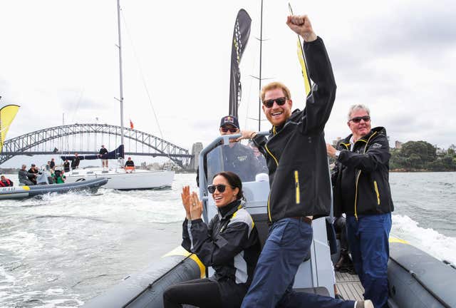 The Duke and Duchess of Sussex cheer on competitors taking part in a sailing event at the 2018 Invictus Games in Sydney harbour (PA)