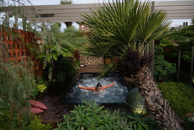 A woman uses a garden with a hot tub during the RHS Chelsea Flower Show press day at the Royal Hospital Chelsea, London 