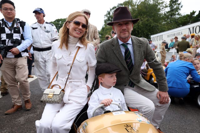 Geri and Christian Horner pose with their son Monty, who sits in a racing car