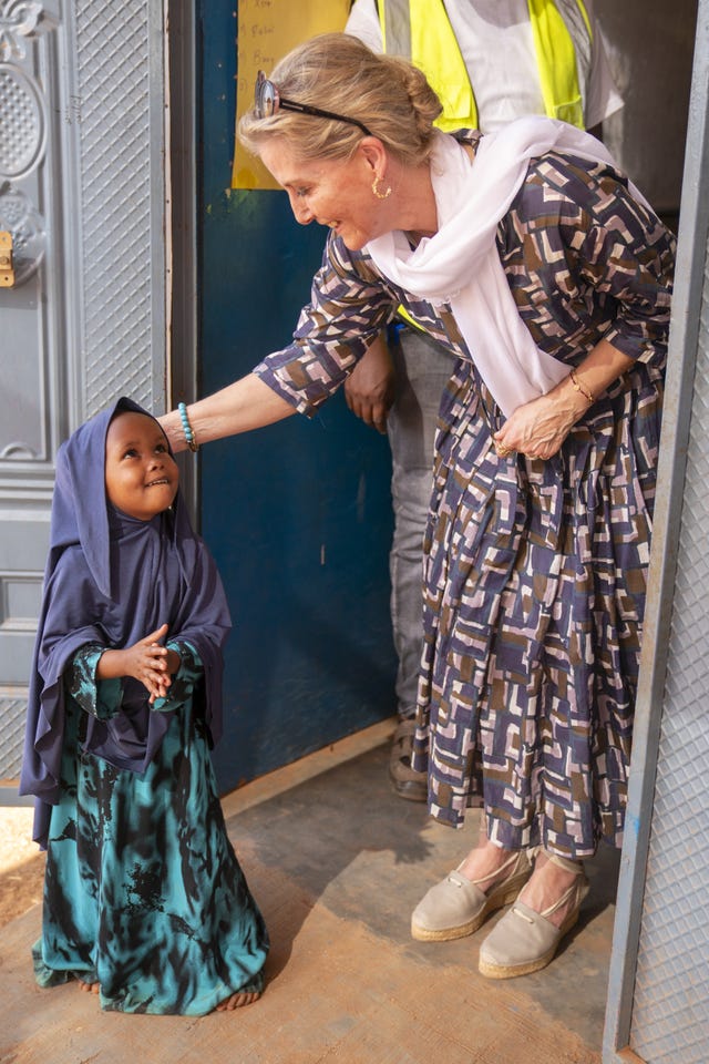 The duchess places her hand on a young girl's head as they meet in a Somali village