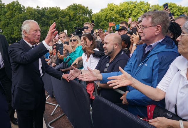 Charles is greeted by well-wishers during a walkabout to view tributes left outside Buckingham Palace