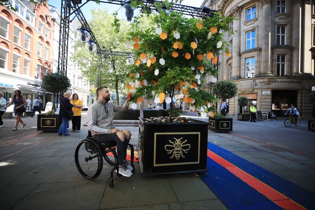 Martin Hibbertt, who suffered life-changing injuries in the Manchester terror attack, reads messages left on a ‘Tree of Hope’ in St Ann’s Square, Manchester (Peter Byrne/PA)