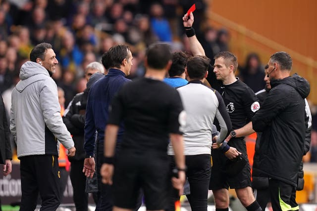 Referee Michael Salisbury, third right, shows a red card to Wolves substitute Matheus Nunes, hidden