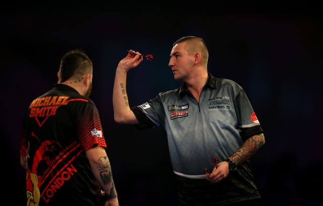 Michael Smith watches Nathan Aspinall throw during their PDC World Championship semi-final