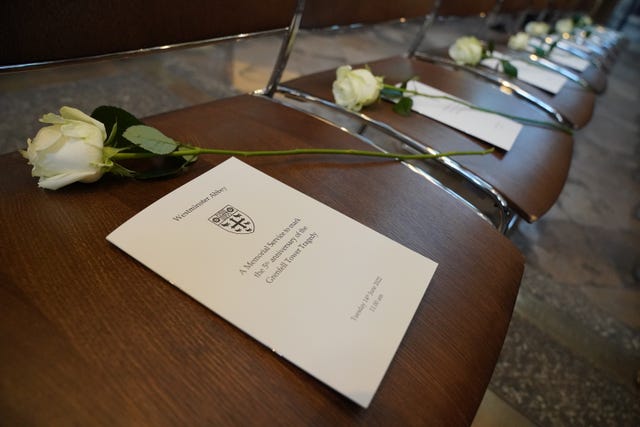 An order of service and a white rose placed on chairs at the Grenfell fire memorial service at Westminster Abbey in London