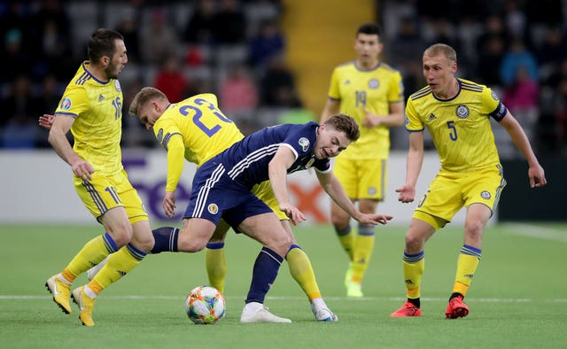 Kazakhstan players crowd a Scotland player