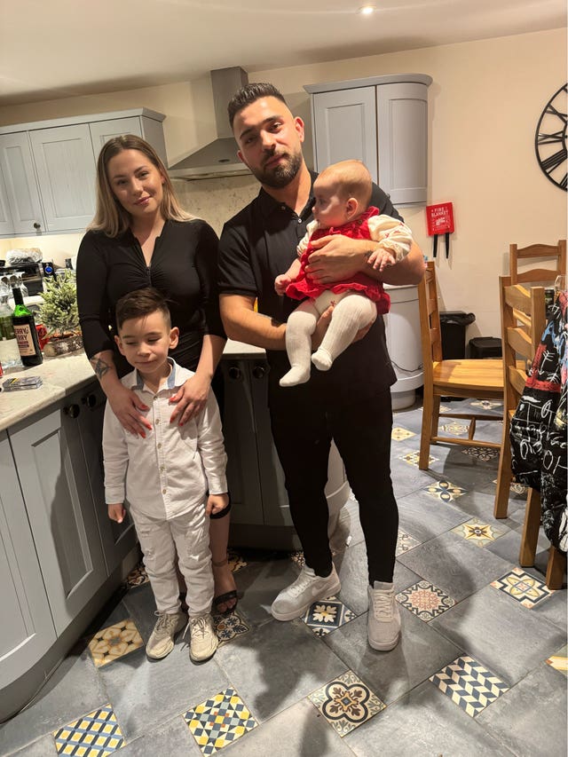 Sophia Kelemen being held by her father, with her mother and elder brother standing next to them