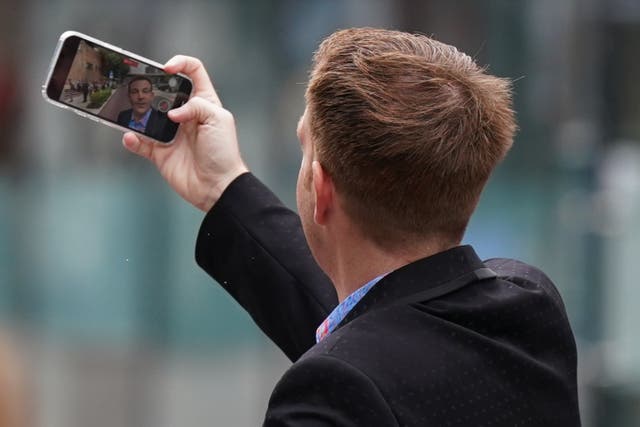 Ex-BBC presenter Alex Belfield taking a picture on his phone as he arrives at Nottingham Crown Court earlier this month