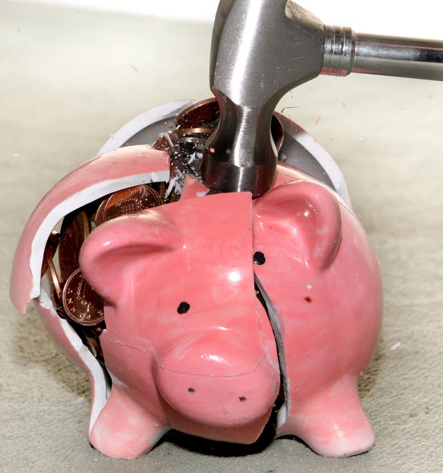 A piggy bank being smashed with a hammer