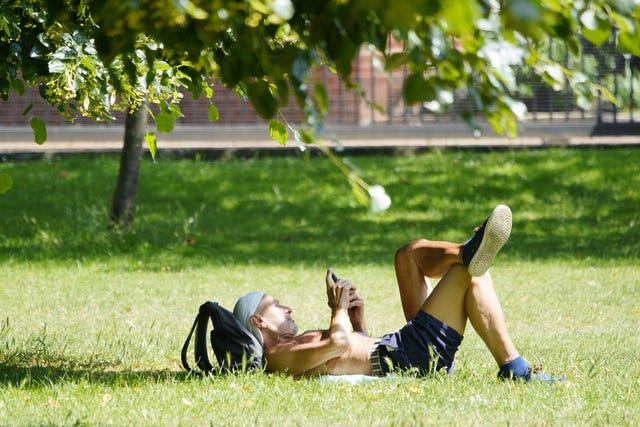 A person sunbathes in Richmond Green, south-west London