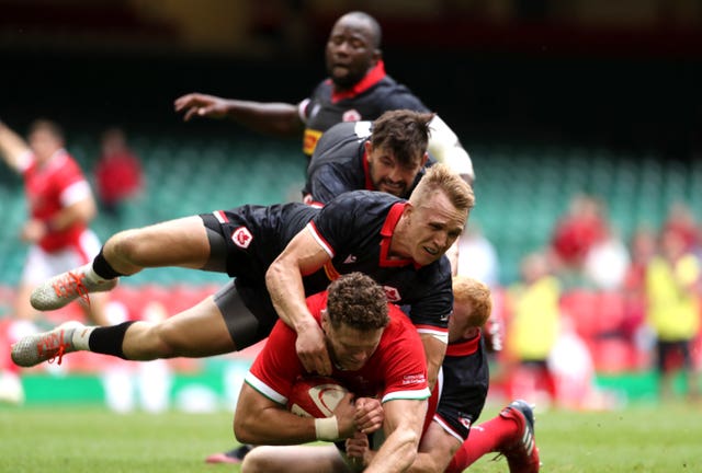 Will Rowlands is tackled by Canada's Peter Nelson