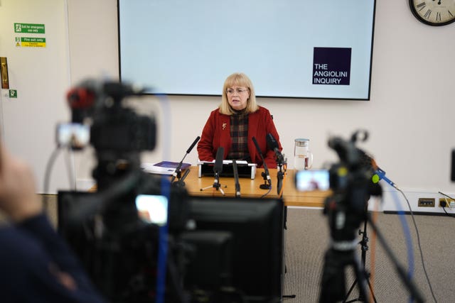 Lady Elish Angiolini sitting behind a desk in front of TV cameras