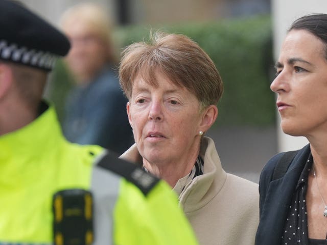 Paula Vennells walks behind a policeman