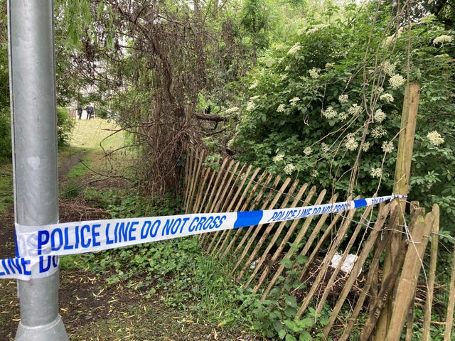 Police tape cordoning off a wooded area