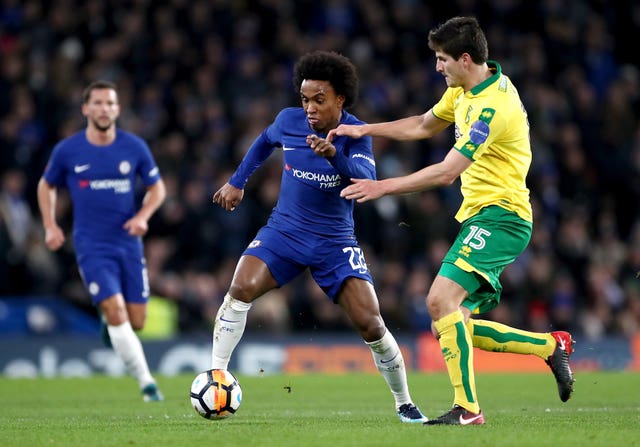 Chelsea's Willian runs with the ball as Norwich defender Timm Klose attempts a tackle