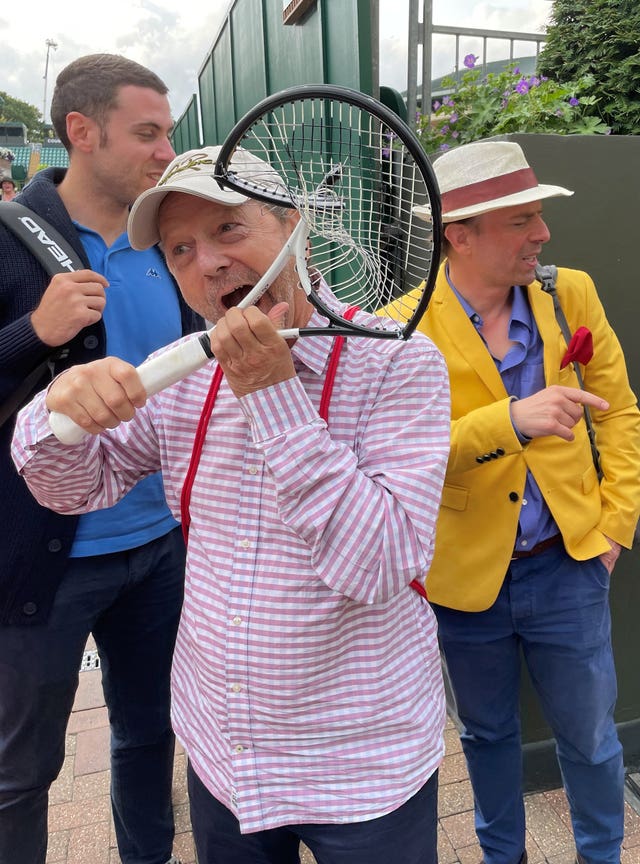 A tennis fan with the broken racket of Novak Djokovic
