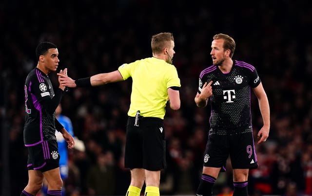 Bayern Munich’s Harry Kane, right, speaks to referee Glenn Nyberg