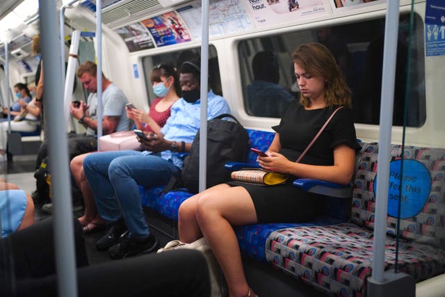 Commuters, some not wearing face masks, on a Jubilee Line train