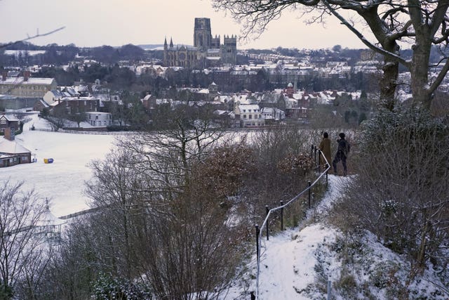 People take pictures from Pelaw Wood of a snow-covered Durham Cathedral 