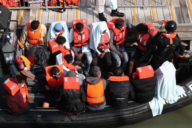 A group of people, thought to be migrants, waiting on a Border Force rib to come ashore at Dover marina in Kent (Gareth Fuller/PA)