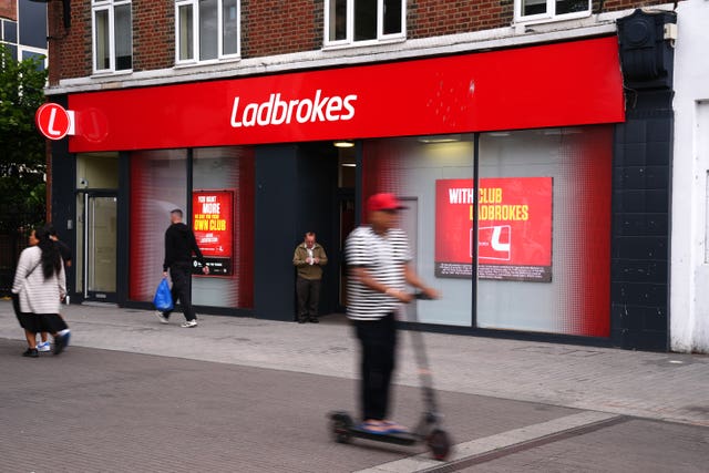 A member of the public walks past a Ladbrokes shop 