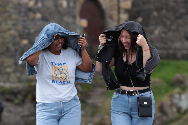 Giselle Munoz Alarcon (left) and Dominic Sepulveda Gutierrez shield from the wind at Carrickfergus Castle, Co Antrim