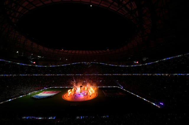 La pyrotechnie explose autour d'une réplique à grande échelle du trophée de la Coupe du Monde de la FIFA sur le terrain avant le match de quart de finale de la Coupe du Monde de la FIFA au stade Lusail