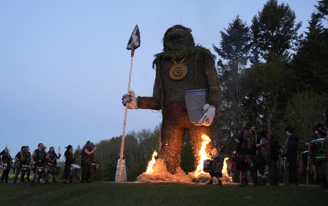 Members of the Pentacle Drummers perform in front of a burning wicker man during the Beltain Celtic Fire Festival at Butser Ancient Farm, near Waterlooville, Hampshire