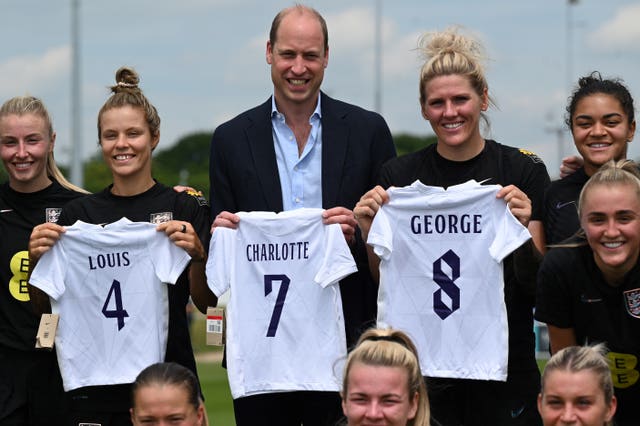 William with Daly, second left, and her England teammates holding football jersey bearing the names of his three children (