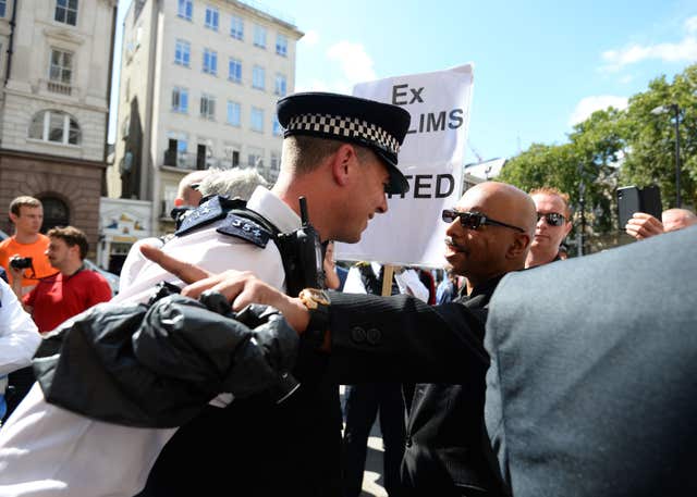 Police get between demonstrators outside the Royal Courts of Justice