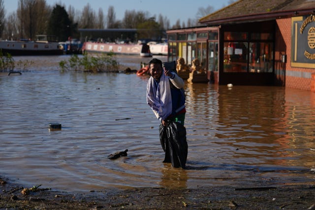 A man smiling stood in floodwater