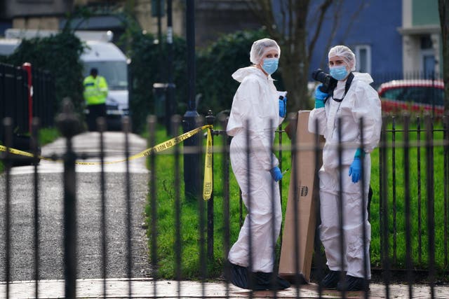 Forensic officers in white overalls