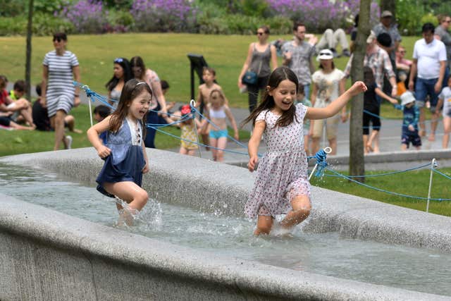 Children cool off in the Diana Memorial Fountain in Hyde Park, London (John Stillwell/PA)