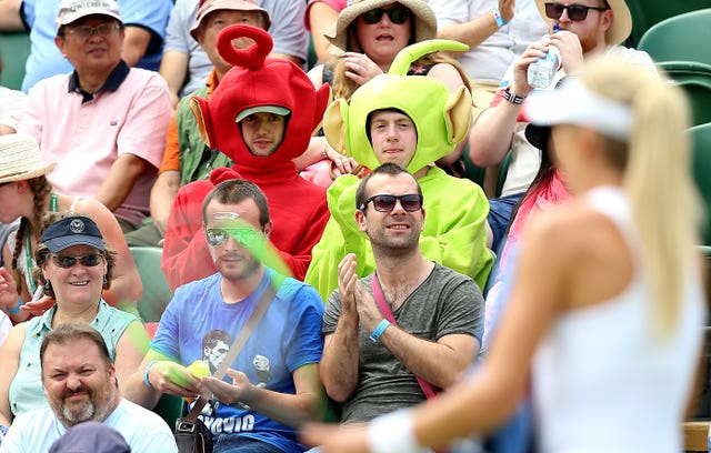 Katie Boulter walks past spectators dressed up as the Teletubbies on court two
