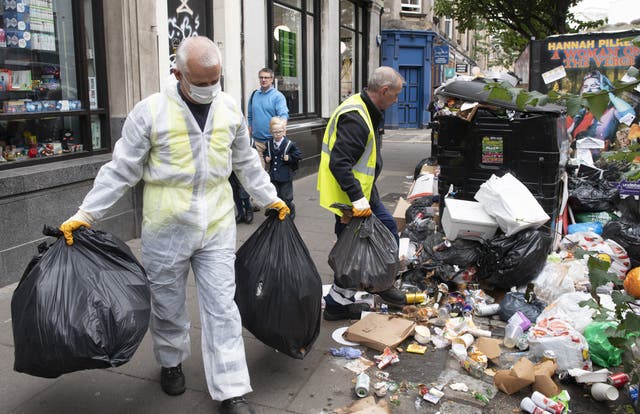 Workers cleaning piles of rubbish in Edinburgh