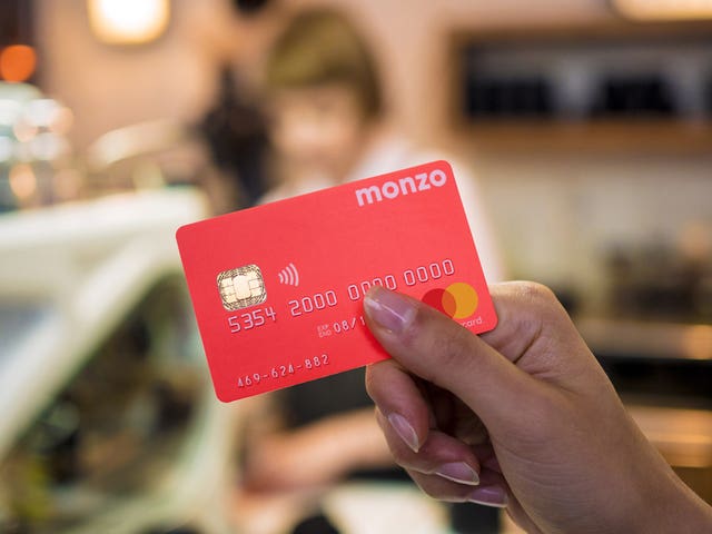 A woman's hand holding a Monzo bank card