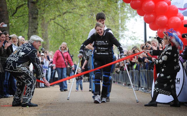 Claire Lomas approaching the finish of the London Marathon on The Mall with the aid of her husband Dan, 16 days after the race began.