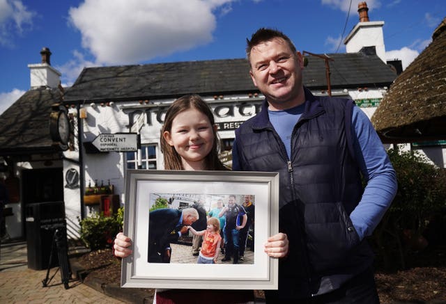 Aoibhinn Brennan and Shane Brennan holding a photo from the 2016 visit