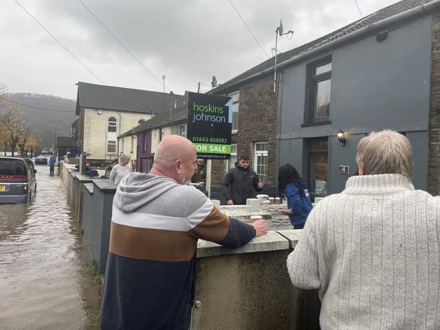 Residents attend to their properties on Sion Street in Pontypridd, Wales, following flooding.