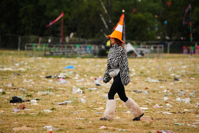 A festival goer walks amongst the waste