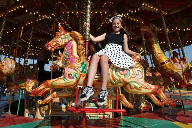 A young visitor enjoys the carousel at the vintage funfair
