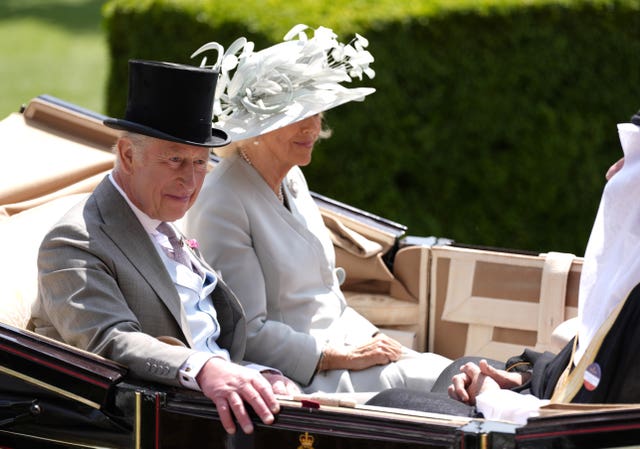 The King and Queen ride in a coach at Royal Ascot 
