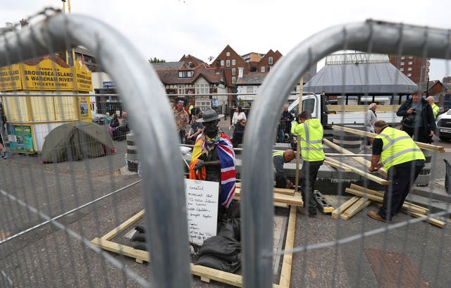 The statue is boarded up (Andrew Matthews/PA)